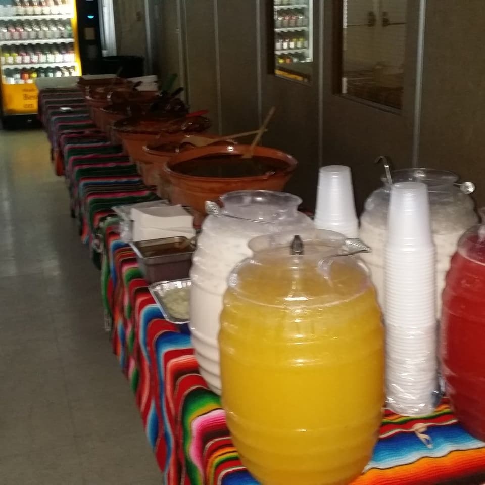 Tables laid end to end with drinks dispensers and food for a party